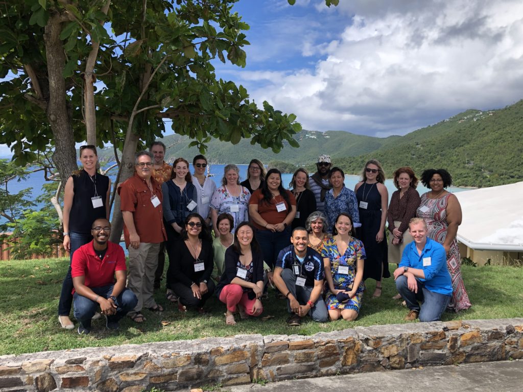 Group photo at the SEAS Islands Alliance Kick-off Meeting at the University of the Virgin Islands, with the sea and hills visible behind