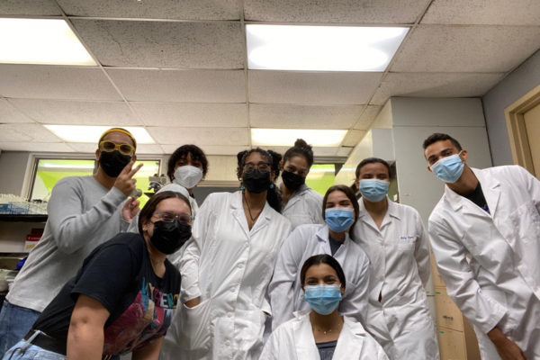 A group of students wearing lab coats in the laboratory.